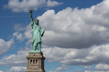 Obraz premium Statue of Liberty (Liberty Enlightening the World), USA freedom and democracy symbol in full size with blue sky and white clouds on back side