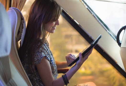 Young woman reading an e-book in the bus