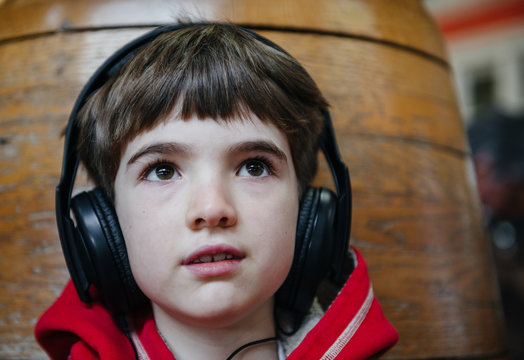 Child wears headphones while listening to music on an mp3 player