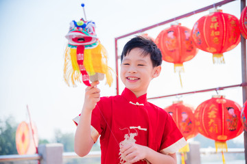 Young chinese boy playing lion puppet in chinese new year festival