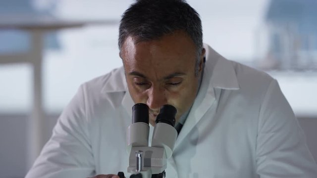 Portrait smiling medical researcher working in the lab analyzing plant sample