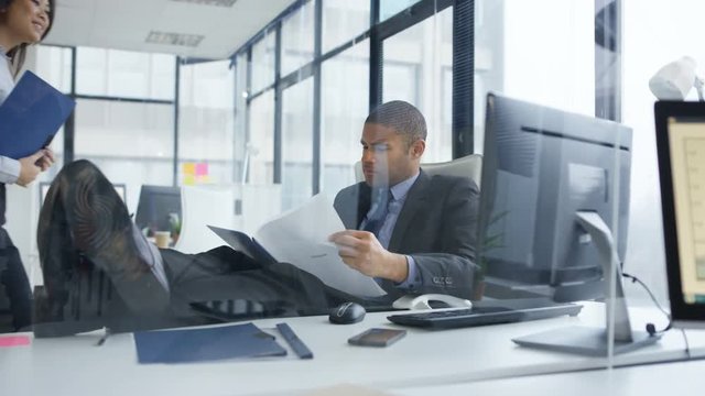  Laid back businessman with feet on the desk in the office