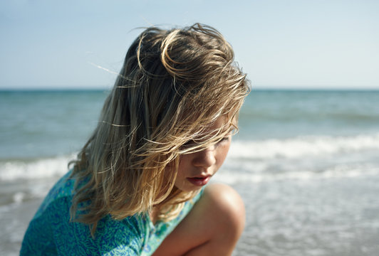 Close up of a blond little girl playing at the beach