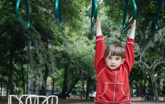 Child plays on the monkey bars at a playground