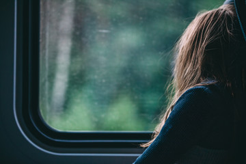 Young woman looking through train window traveling