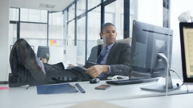  Laid back businessman with feet on the desk in the office