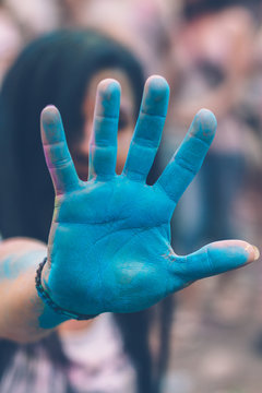 young woman holding up her blue colored hand for a high five