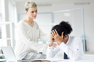 Young female comforting her colleague worried about work problems