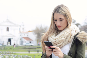 Young woman sending messages with her smartphone.