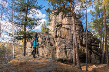 Fototapeta na wymiar The hiker girl is standing next to the rock