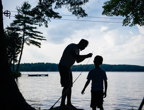 Dad helps son with his fishing pole