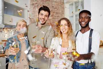 Cheerful couples celebrating holiday and toasting with champagne at party
