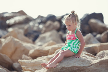 Little cute happy girl bathes in sea,