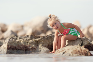 Little cute happy girl bathes in sea,