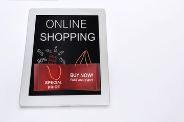 Online shopping website and shopping bag on white computer tablet on white background