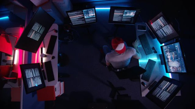  Overhead view looking down, computer hacker surrounded by computer screens