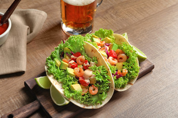 Board with delicious shrimp tacos on table