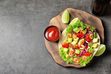 Board with delicious shrimp taco and sauce on table