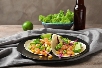Plate with delicious shrimp tacos on table