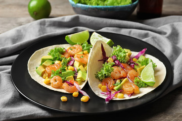 Plate with delicious shrimp tacos on table