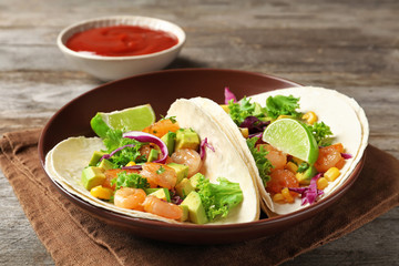 Plate with delicious shrimp tacos on table