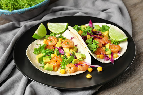 Plate with delicious shrimp tacos on table