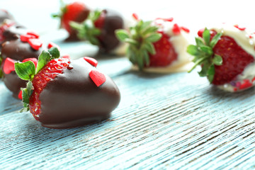 Tasty glazed strawberries on wooden background