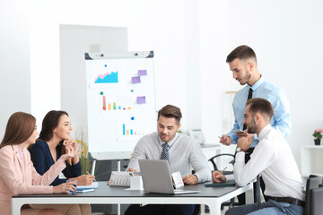 Team of young managers discussing project in office