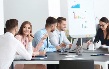 Team of young managers discussing project in office