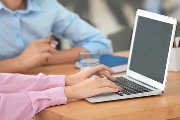 Young woman using laptop on table in office © Africa Studio