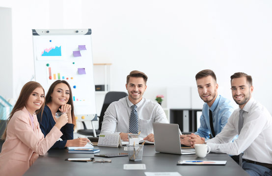 Team of young managers discussing project in office