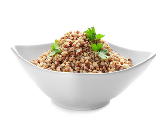 Bowl with cooked buckwheat on white background