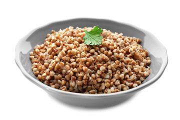 Bowl with cooked buckwheat on white background