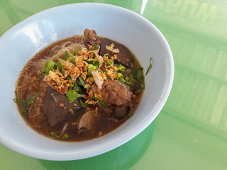 Duck noodles in a bowl on a table.