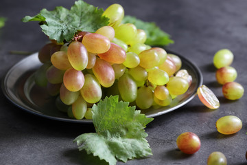 Plate with fresh ripe grapes on table