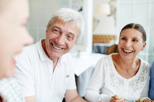 Laughing Mature Man And Woman Listening To Their Companion During Talk At Leisure