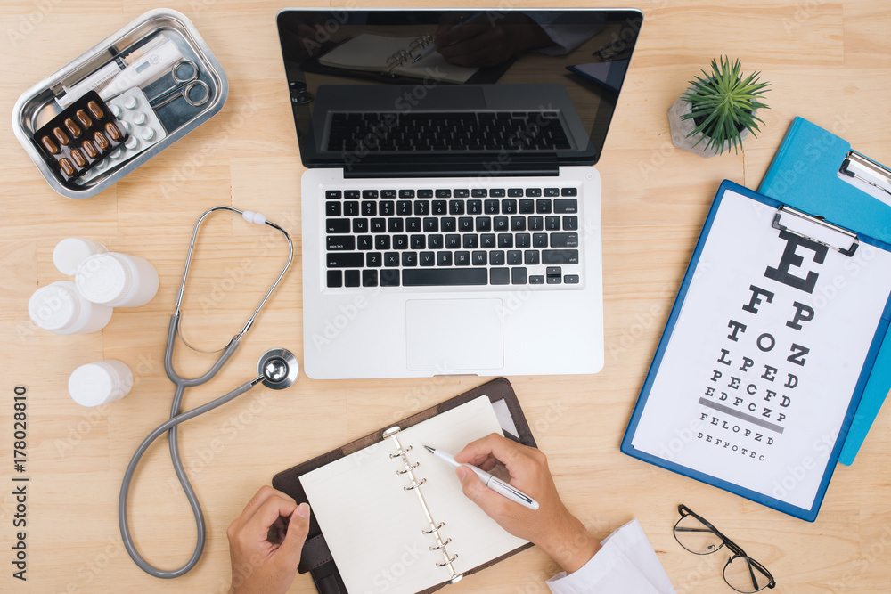 Aufkleber doctor working at desk table with stethoscope and notebook with a visual test chart