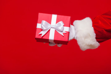 christmas Photo of Santa Claus gloved hand with red giftbox