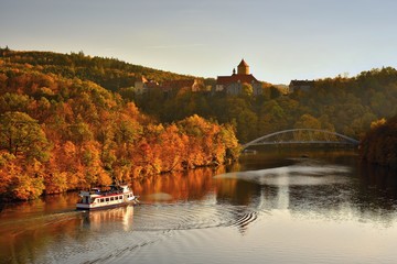 Beautiful Autumn Landscape with Veveri Castle. Natural colorful scenery with sunset. Brno dam-Czech Republic-Europe. Ship at the Brno dam. - obrazy, fototapety, plakaty