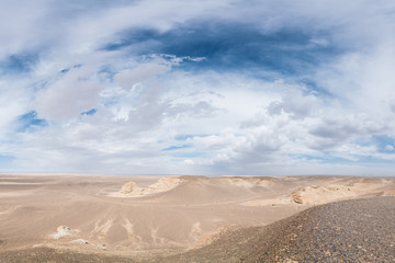 beautiful sunlit white desert with fluffy clouds on blue sky 
