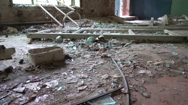 Chernobyl, Ukraine - 17th of June 2017: Visit to Zalesye village in Chernobyl zone - 4K Plenty of broken bottles on the floor of abandoned house