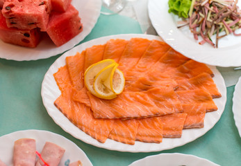 salmon sliced with lemon, salads and fruits