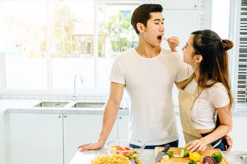 Asian teen couple are helping to make dinner. And bakery together happily. On Valentine's Day in their home.