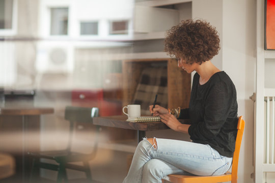 Woman Writing at a Cafe
