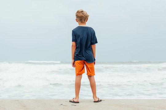 boy on the beach as a hurricane approaches