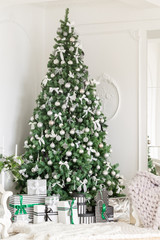 Christmas morning. classic apartments with a white fireplace, decorated tree, bright sofa, large windows