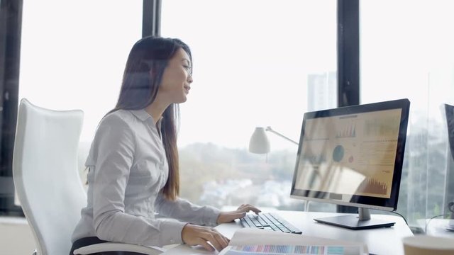  Businesswoman working on computer in corporate office