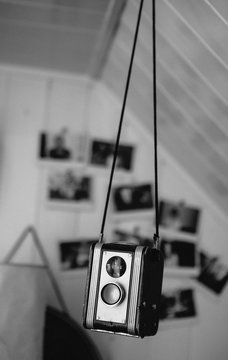 Vintage camera hanging with photographs behind.