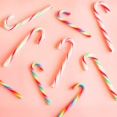 Candy canes on pink background. Square. Flat lay.