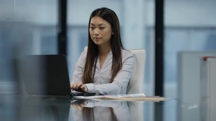  Cheerful relaxed businesswoman working on laptop at her desk
